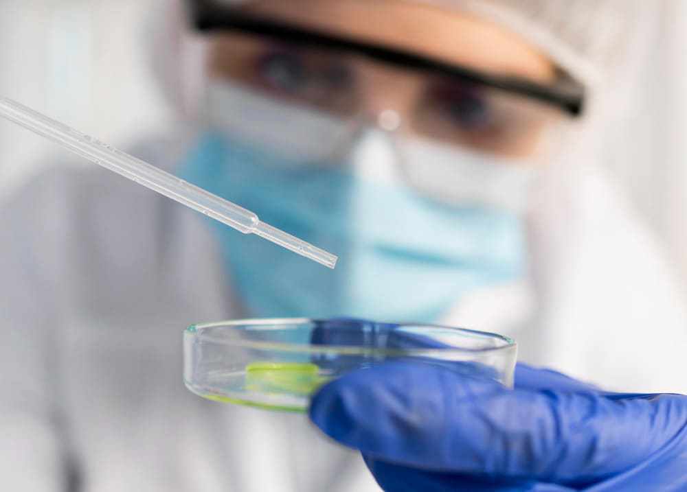 homem com mascara e itens de laboratório indicando teste